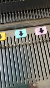 Close-up of arrow needle markers on a Silver Reed main bed