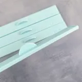 Close-up of the stop tab on a mint green assembly ruler