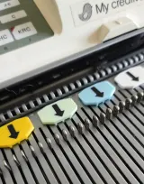 Colourful arrow needle markers marking needle positions on a Brother 5gg