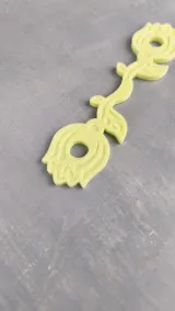 Yellow floral plating yarn holder, close-up
